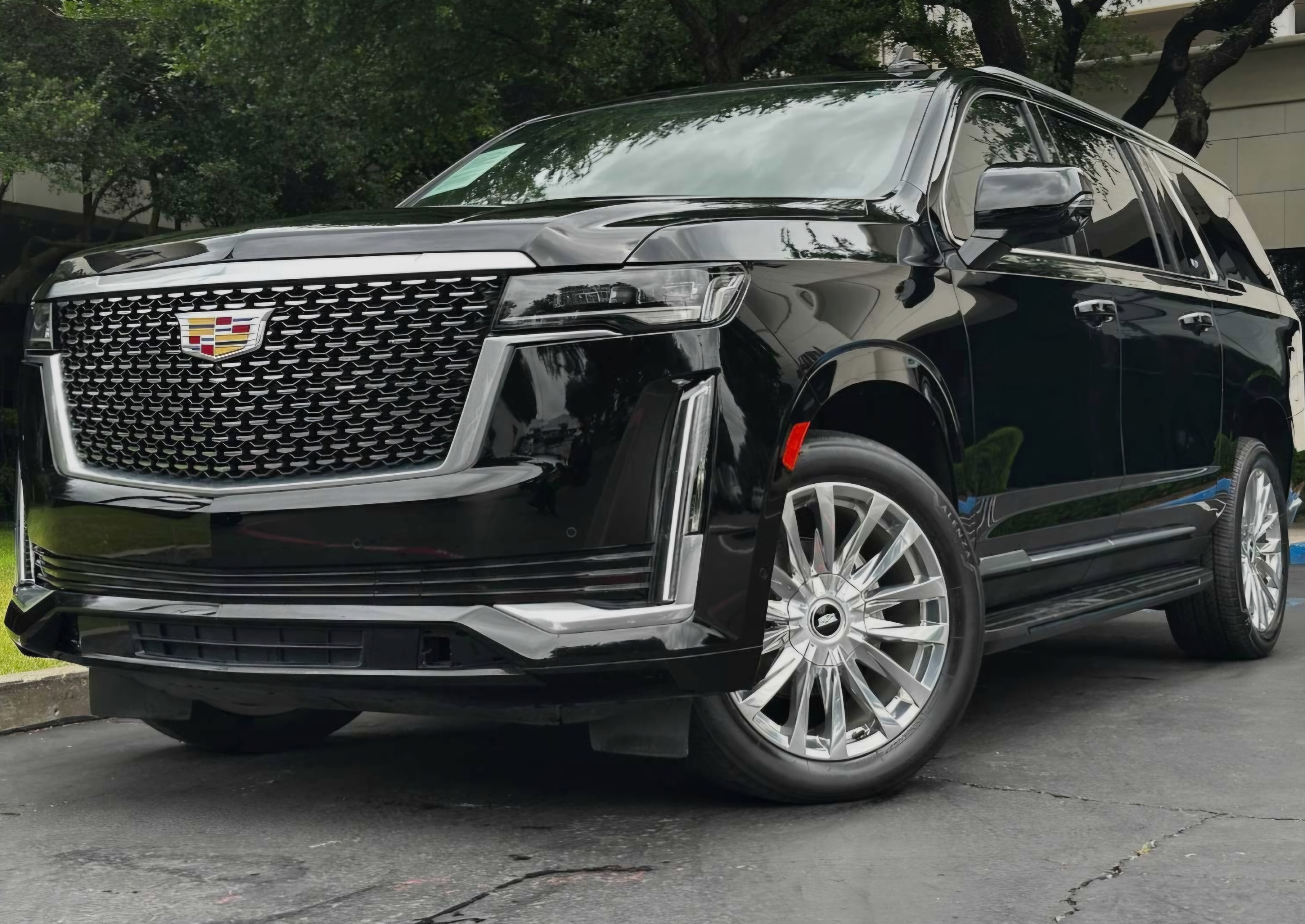 Cadillac Escalade ESV at luxury hotel entrance at night
