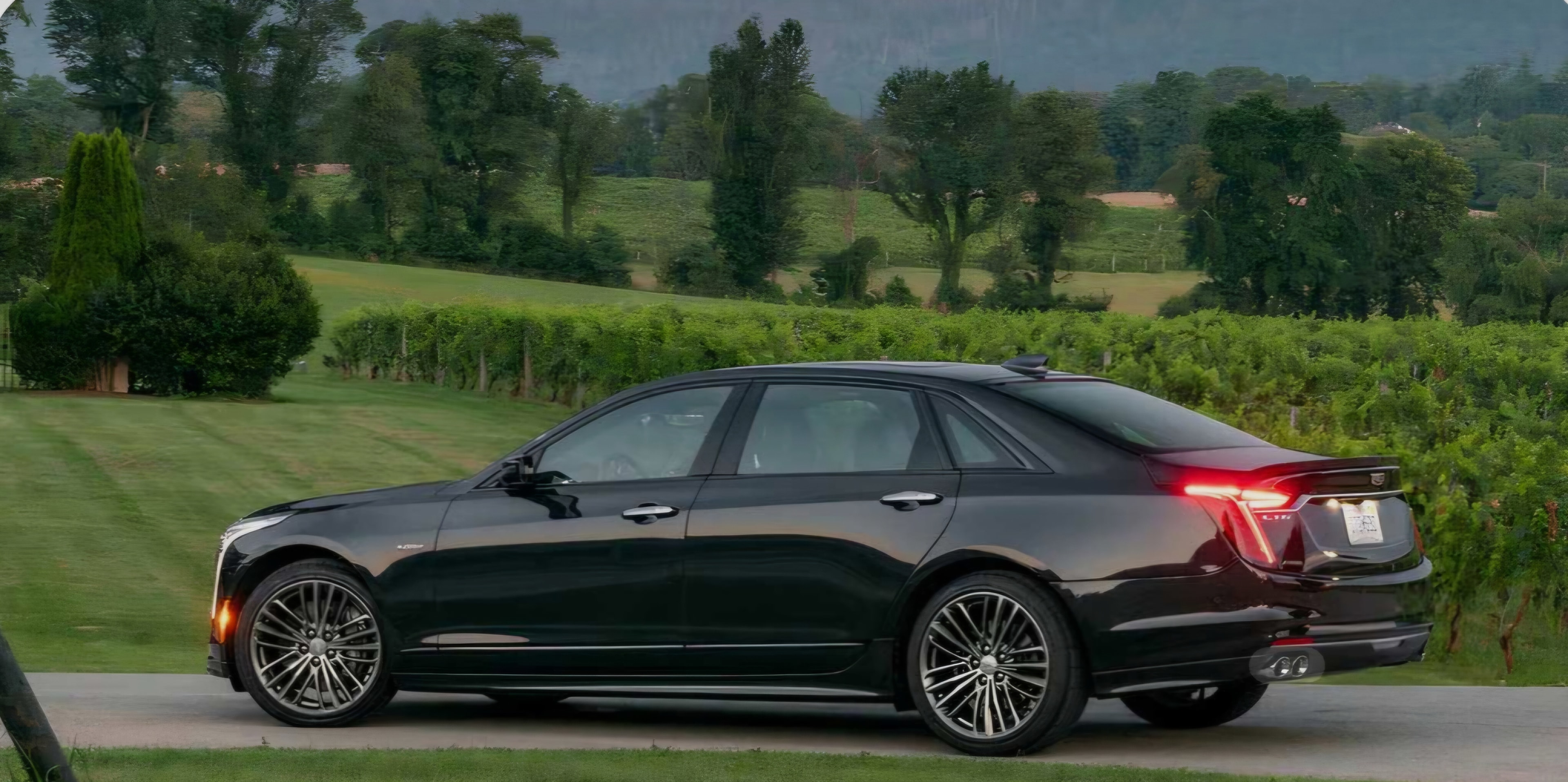 Black Cadillac CT6 side profile on scenic country road